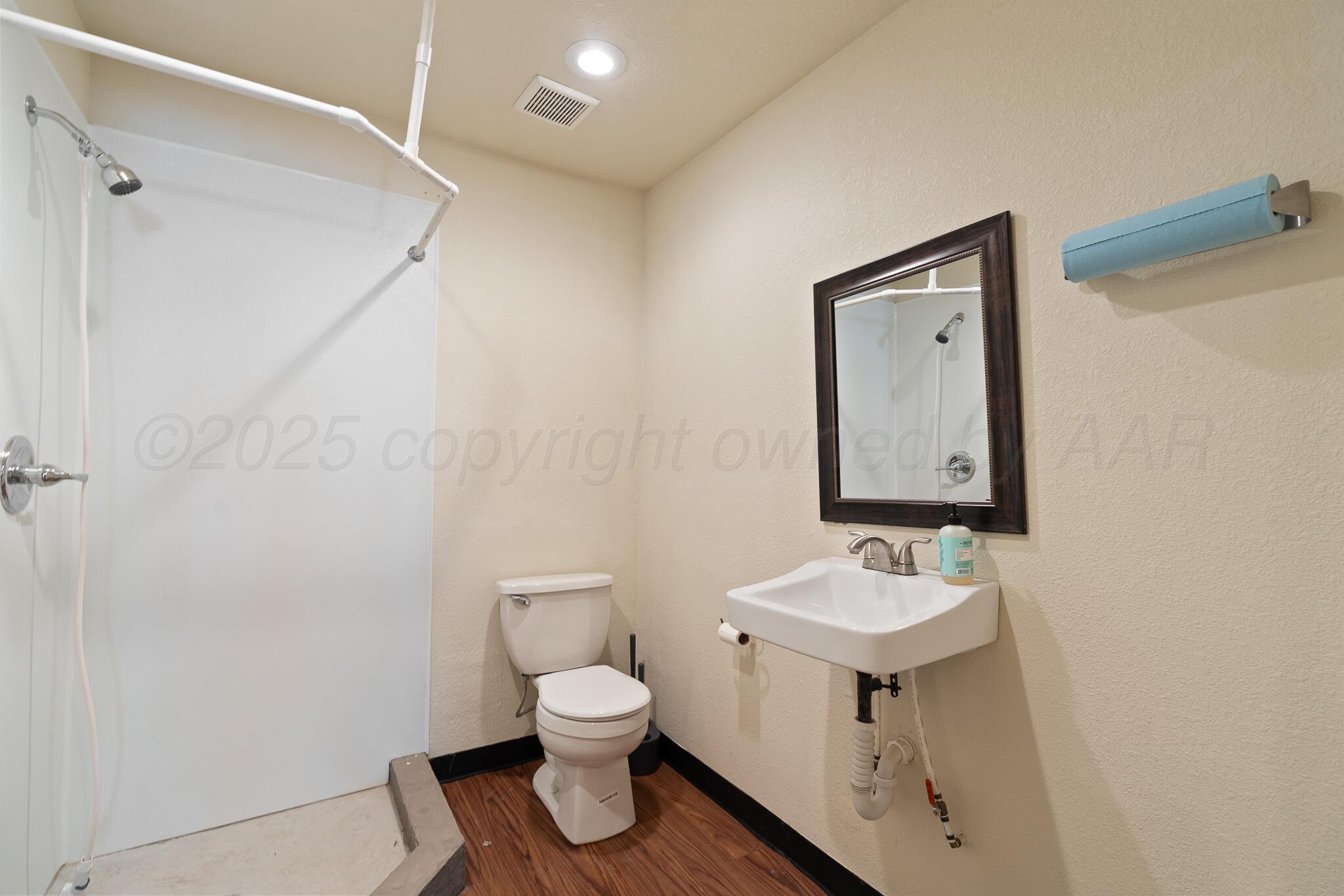 17301 Spring Lake Drive Canyon, TX 79015 - Photo 41 of 62 a bathroom with a toilet sink and mirror