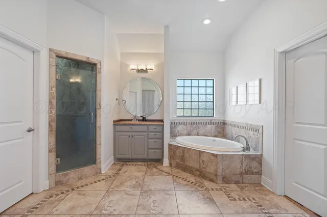 a spacious bathroom with a granite countertop tub shower and mirror