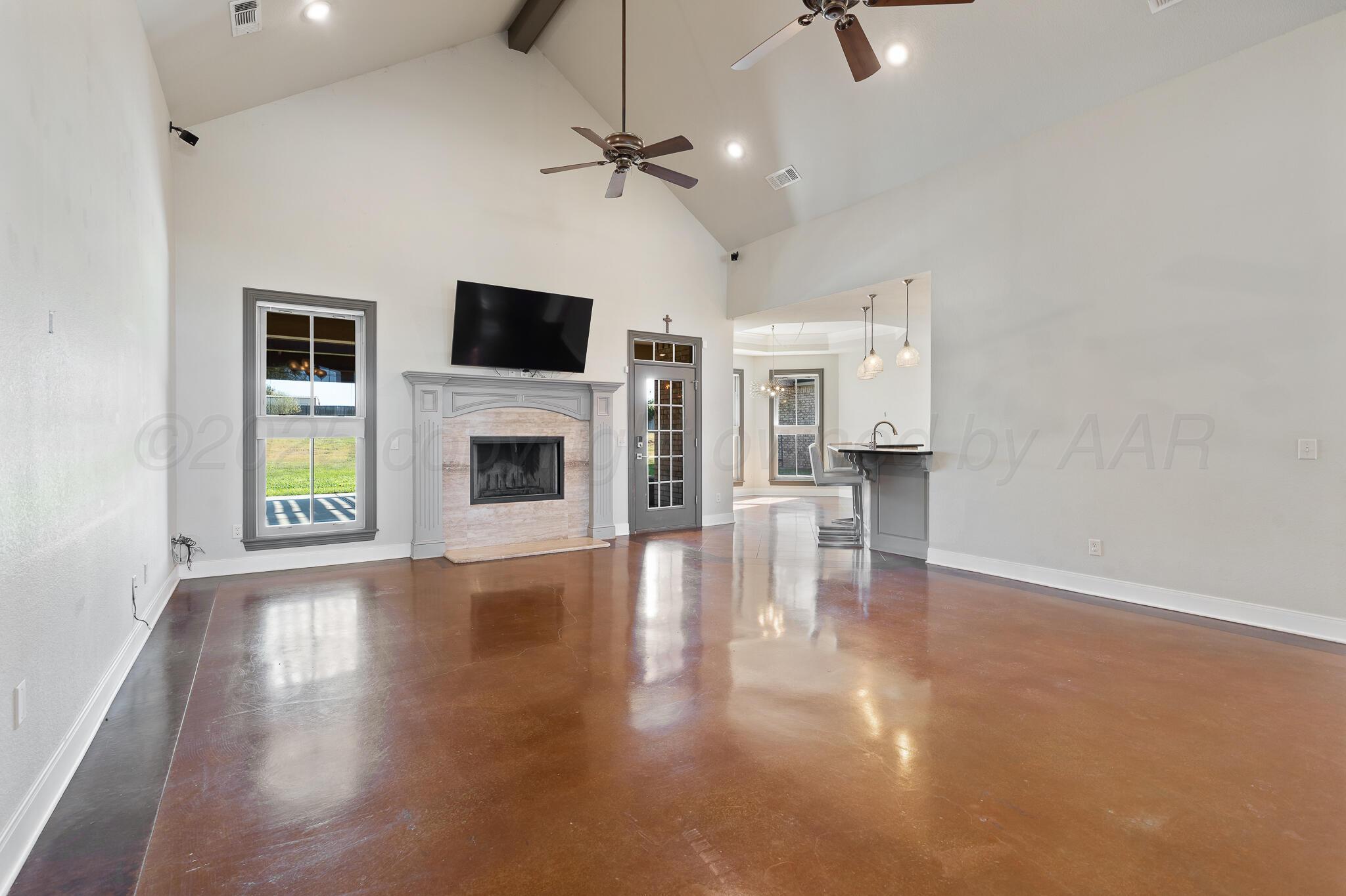 17301 Spring Lake Drive Canyon, TX 79015 - Photo 6 of 62 an empty room with windows fireplace and wooden floor