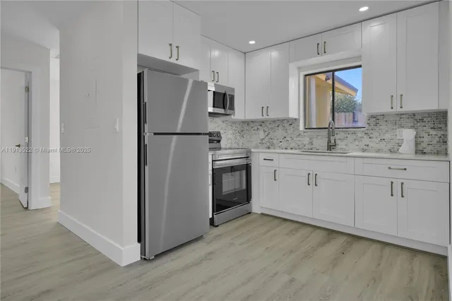 a kitchen with a refrigerator sink and cabinets