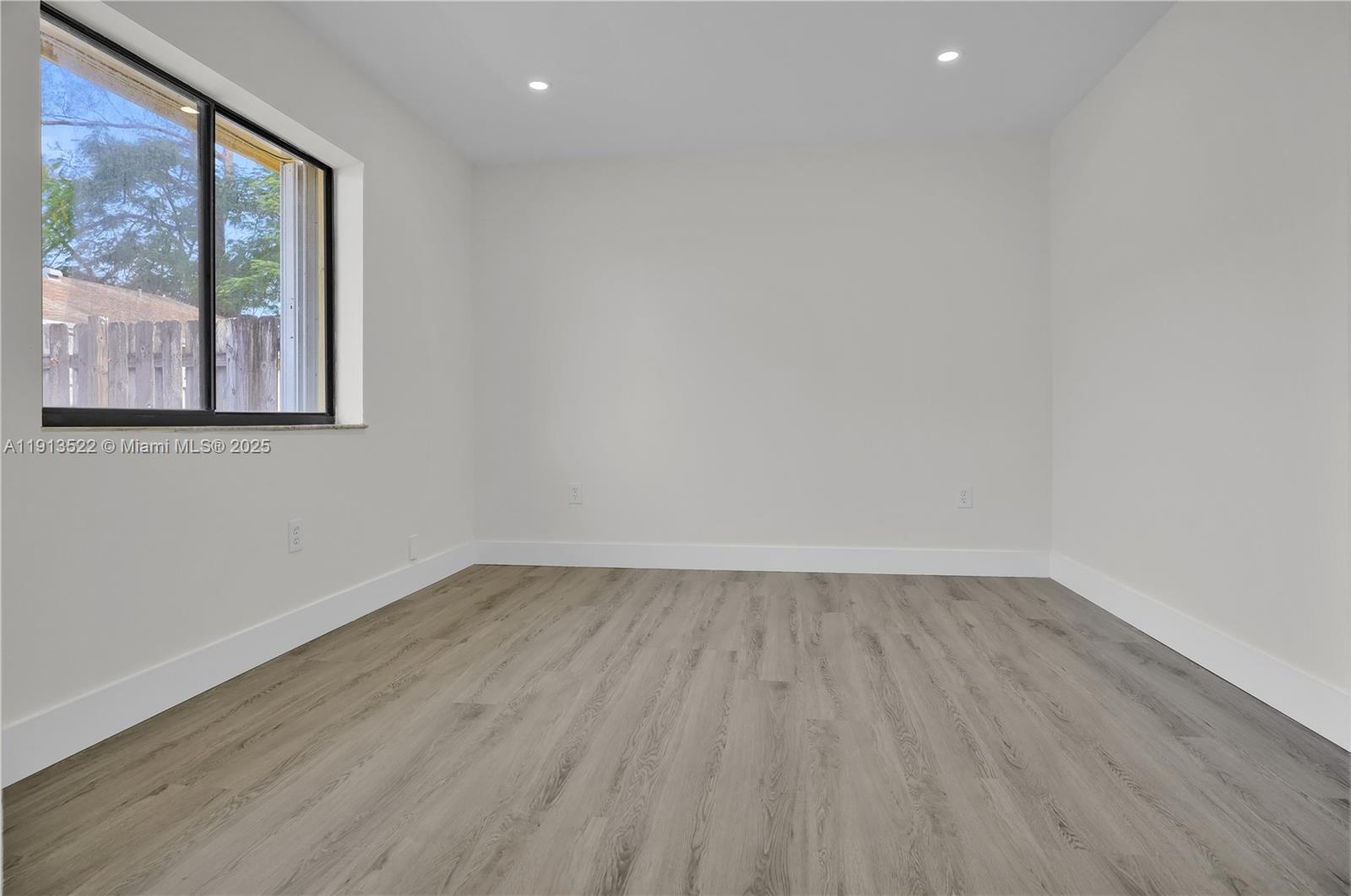 20127 Southwest 88th Court, Unit 20127 Cutler Bay, FL 33189 - Photo 12 of 19 a view of an empty room with wooden floor and a window