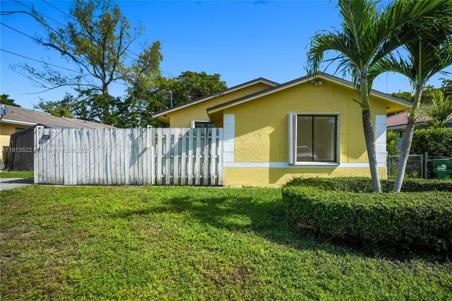 a yellow house with trees in front of it