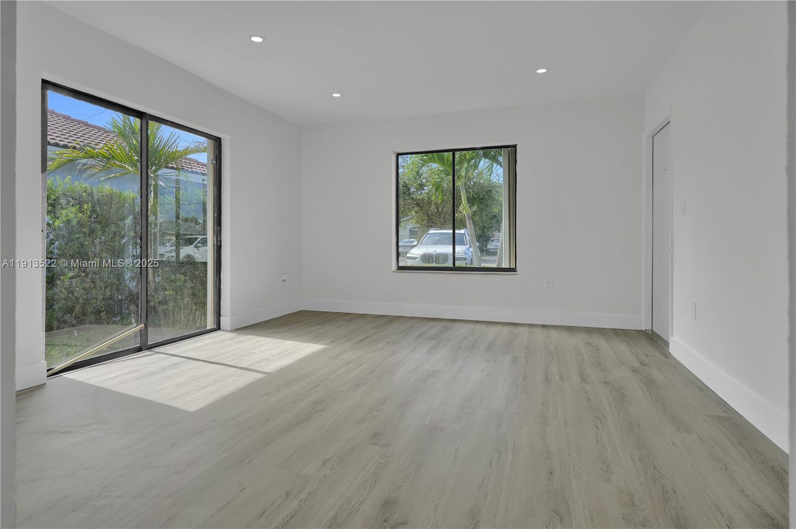 20127 Southwest 88th Court, Unit 20127 Cutler Bay, FL 33189 - Photo 6 of 19 a view of an empty room with wooden floor and a window