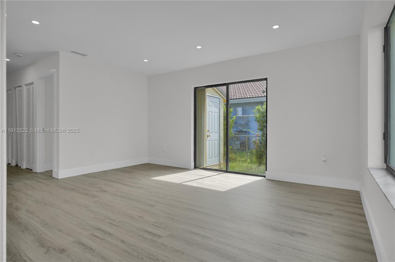20127 Southwest 88th Court, Unit 20127 Cutler Bay, FL 33189 - Photo 7 of 19 a view of an empty room with wooden floor and a window