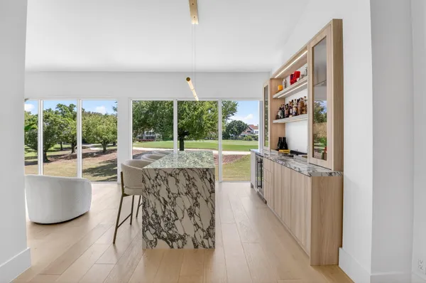 a open kitchen with granite countertop a stove and a large window