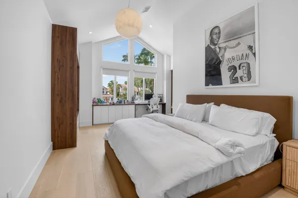 a bedroom with a large bed and a chandelier