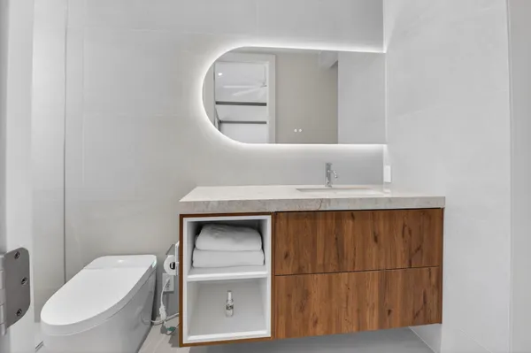 a bathroom with a toilet a sink and mirror