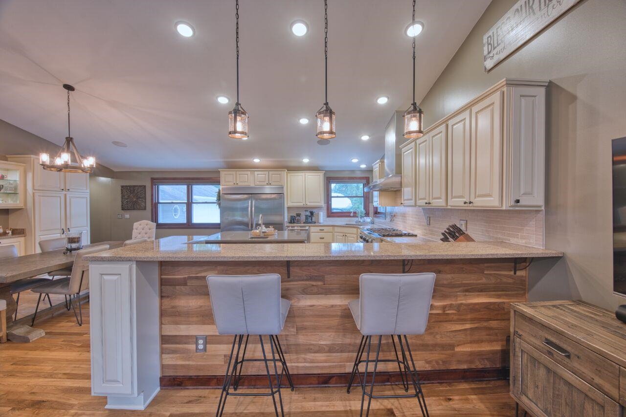3557 Haverkamp Road Hibbing, MN 55746 - Photo 17 of 60 Kitchen featuring stainless steel built in fridge, healthy amount of natural light, a breakfast bar area, light stone countertops, and recessed lighting