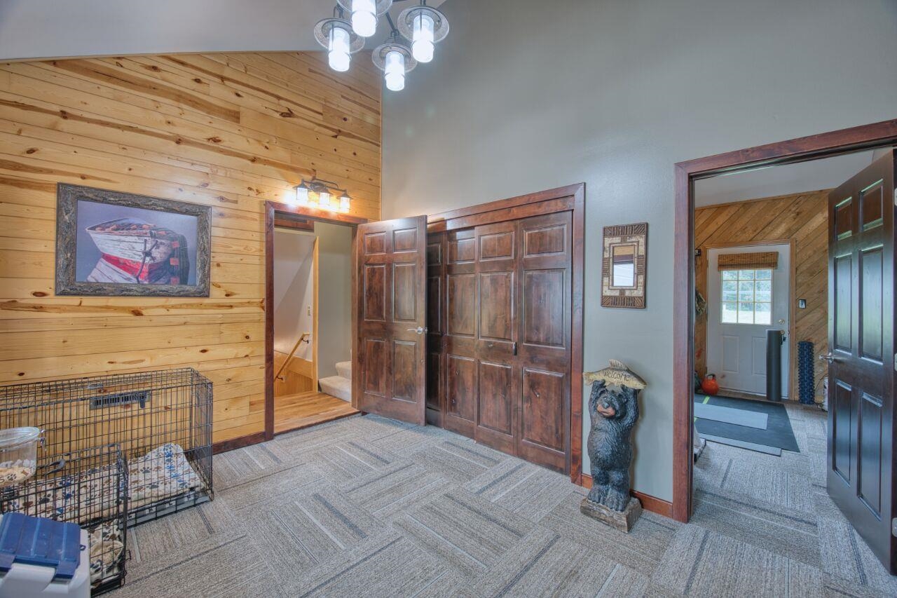 3557 Haverkamp Road Hibbing, MN 55746 - Photo 42 of 60 Carpeted bedroom featuring wood walls, a towering ceiling, and a chandelier