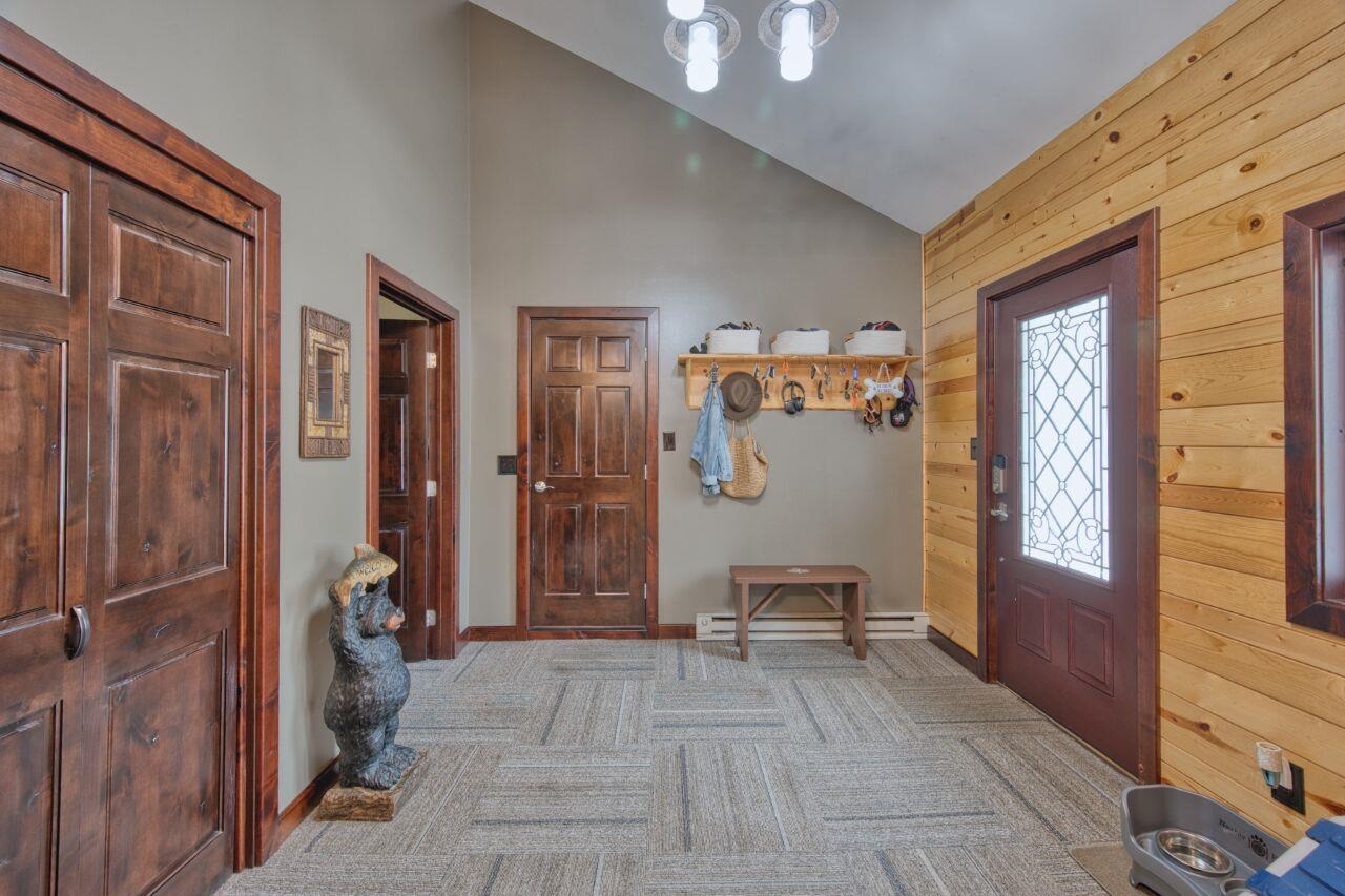 3557 Haverkamp Road Hibbing, MN 55746 - Photo 43 of 60 Carpeted foyer with wooden walls, high vaulted ceiling, and baseboard heating