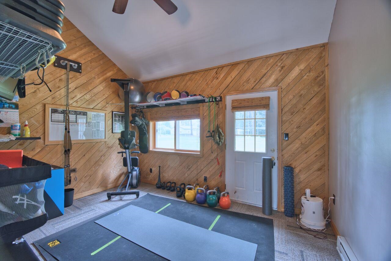 3557 Haverkamp Road Hibbing, MN 55746 - Photo 44 of 60 Workout room featuring wooden walls, a baseboard radiator, and ceiling fan