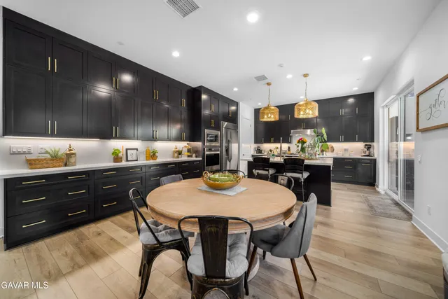 a large kitchen with stainless steel appliances a large counter top a stove and a sink