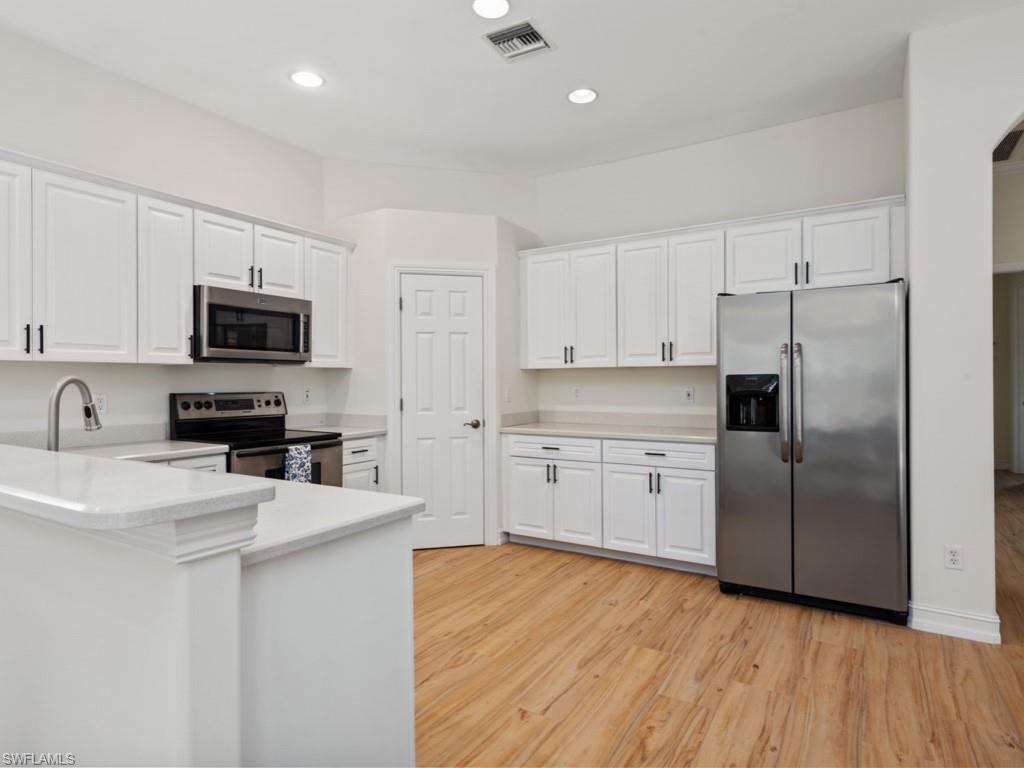 6840 Bent Grass Drive Naples, FL 34113 - Photo 6 of 21 a kitchen with a refrigerator stove microwave and sink