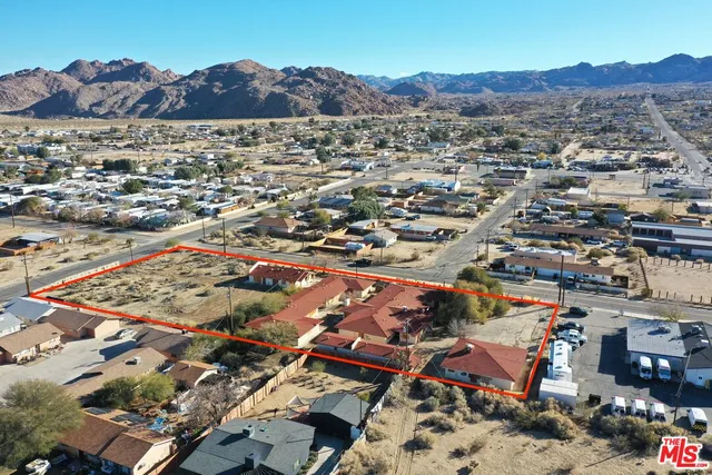an aerial view of a house and a mountain