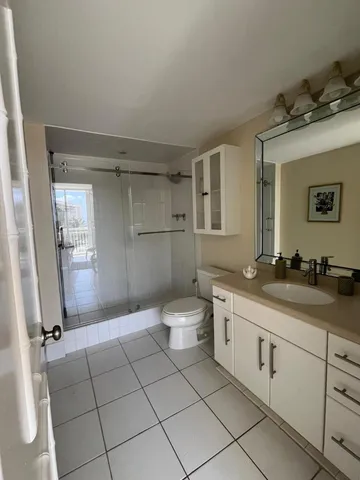 a spacious bathroom with a granite countertop sink a toilet and a mirror