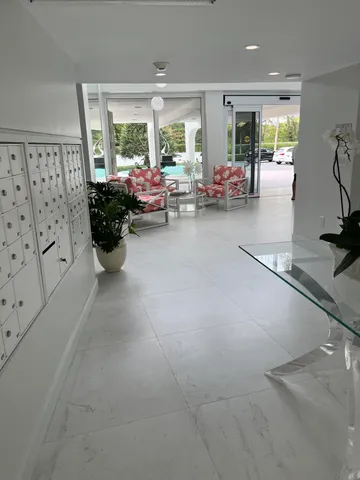 a living room with furniture large window and potted plants