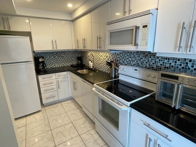 2780 South Ocean Boulevard, Unit 312 Palm Beach, FL 33480 - Photo 9 of 29 a kitchen with granite countertop a sink stove and refrigerator