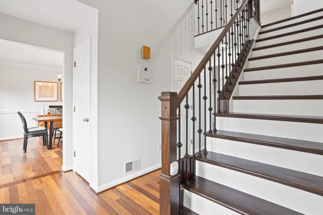 a view of staircase with wooden floor and white walls