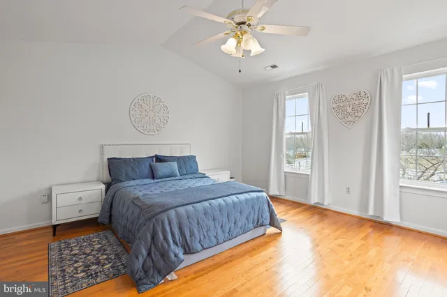 a bedroom with a large bed chandelier and a window