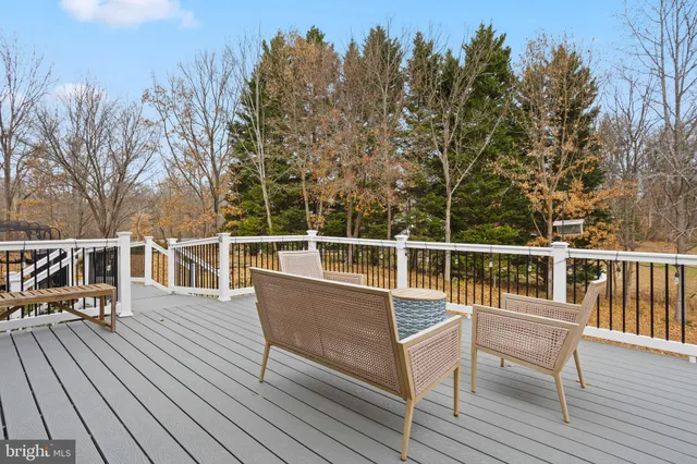 a view of a balcony with wooden floor and outdoor seating