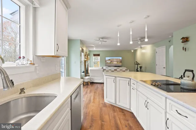 a large kitchen with kitchen island a large counter space a sink appliances and a window
