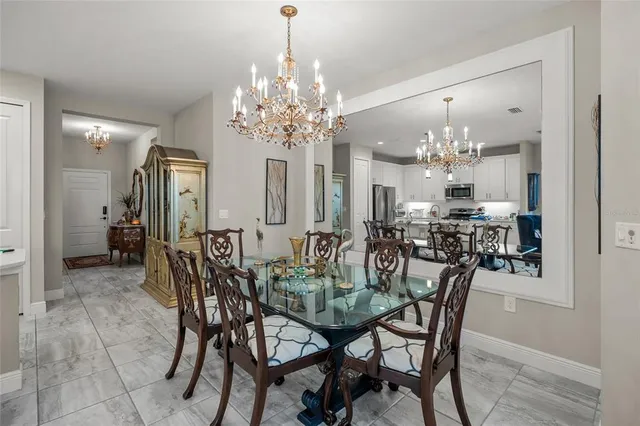 a view of a dining room with furniture a chandelier and wooden floor