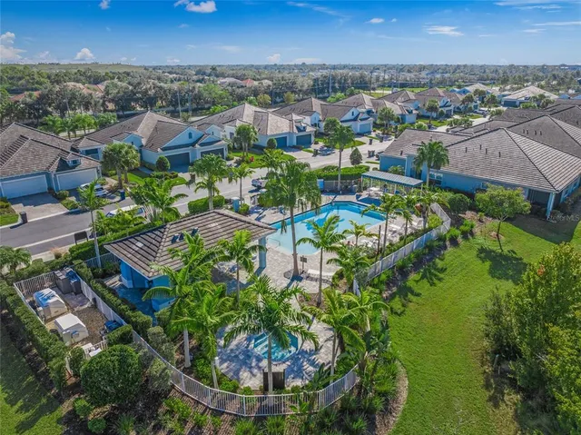 an aerial view of residential houses with outdoor space and swimming pool