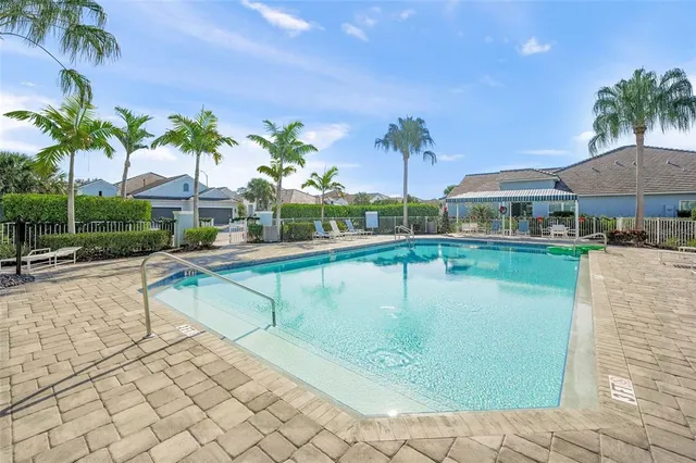 a dining room with furniture a floor to ceiling window and a kitchen view