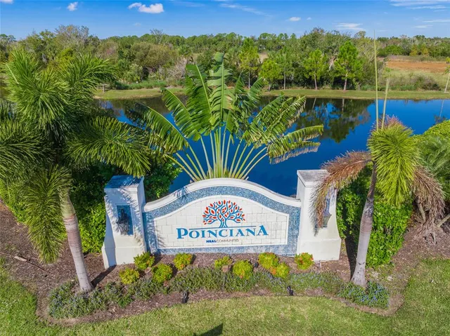 a view of a sign board with buildings in the background