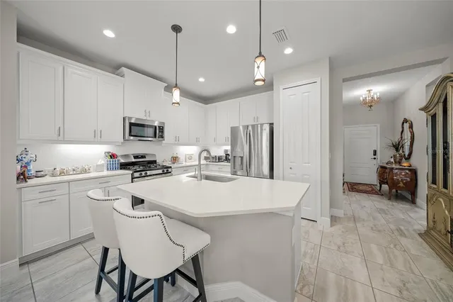 a kitchen with refrigerator a sink and chairs