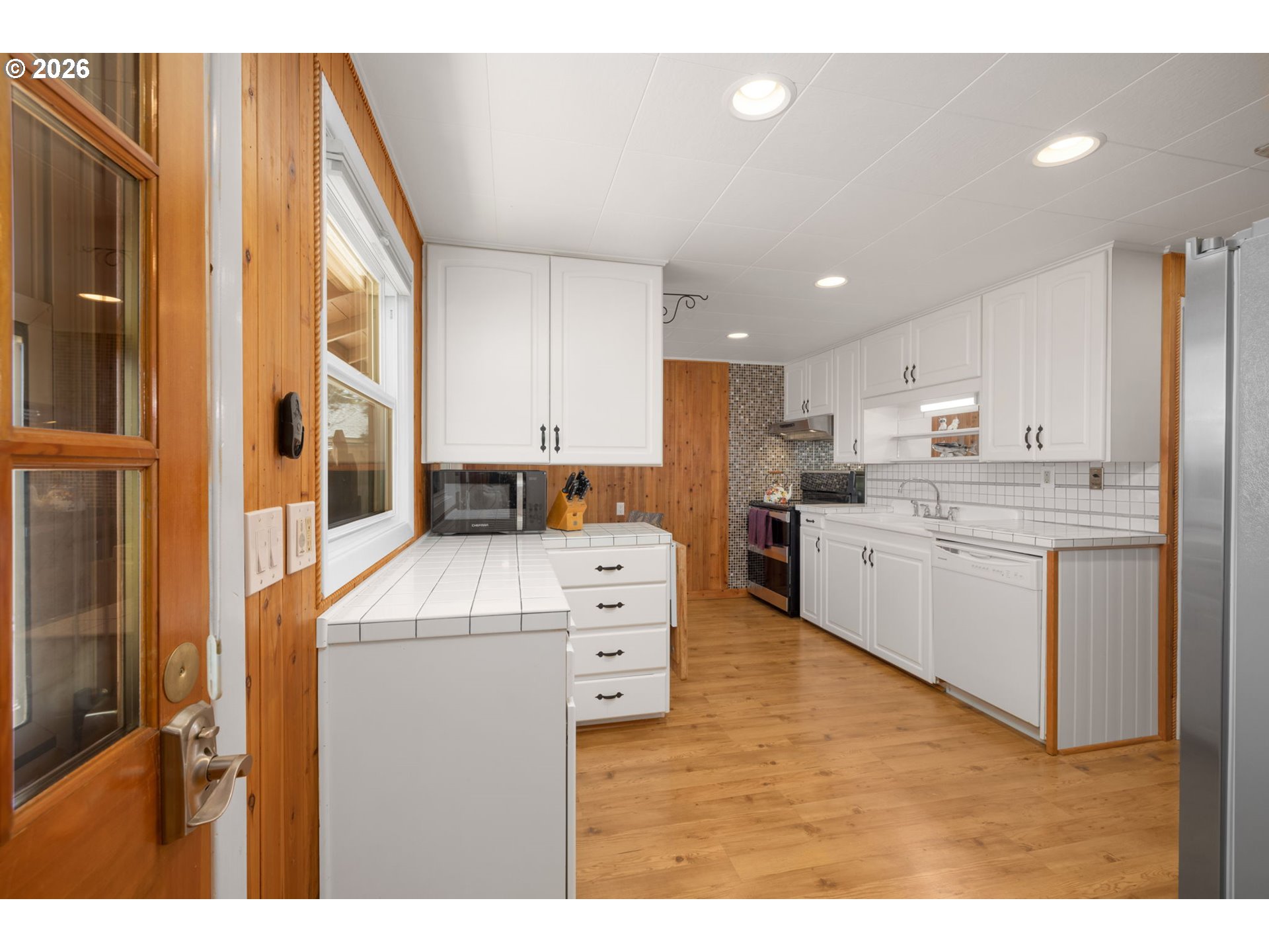 15880 Southeast Bluff Road Sandy, OR 97055 - Photo 16 of 47 a kitchen with a stove a sink and a refrigerator with wooden floor