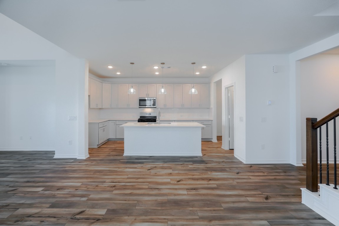 15135 Wild Gully Way Conroe, TX 77302 - Photo 11 of 42 a view of kitchen with kitchen island wooden floor center island and stainless steel appliances