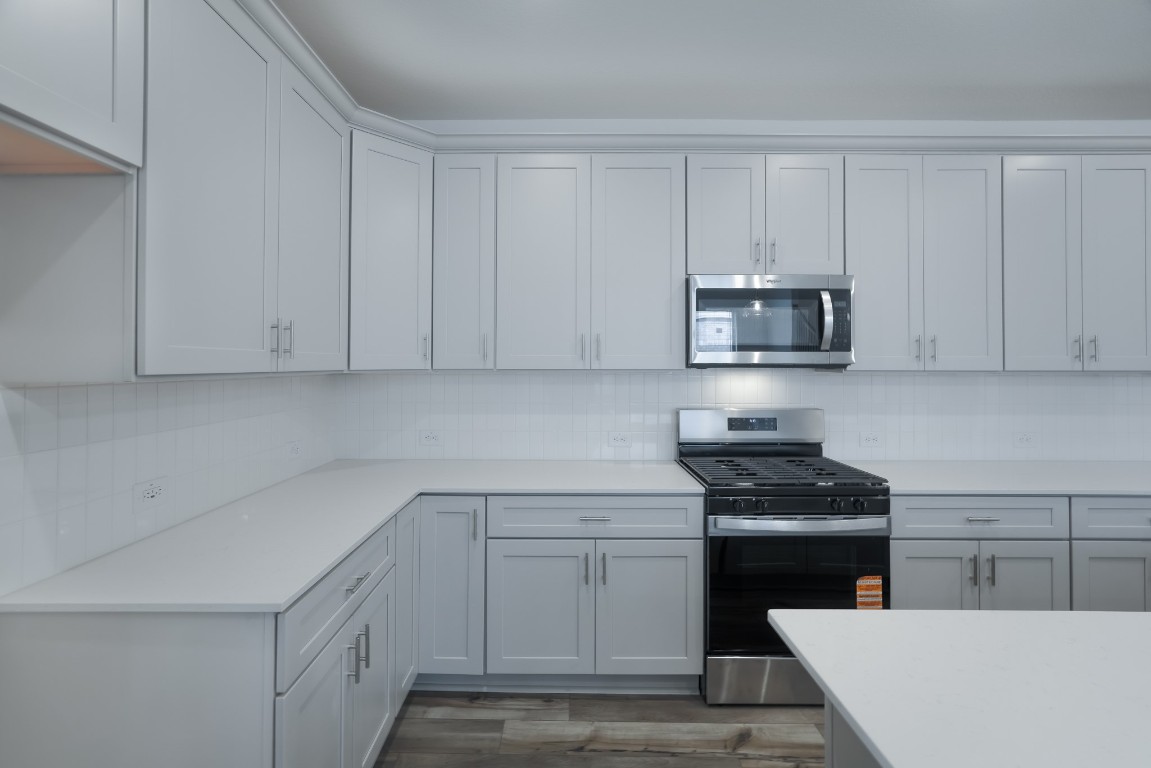 15135 Wild Gully Way Conroe, TX 77302 - Photo 21 of 42 a kitchen with stainless steel appliances white cabinets and a sink