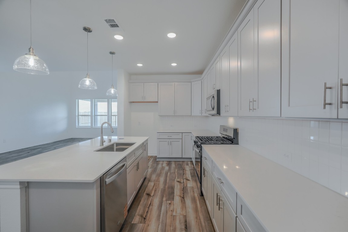 15135 Wild Gully Way Conroe, TX 77302 - Photo 9 of 42 a kitchen with a sink stove and cabinets