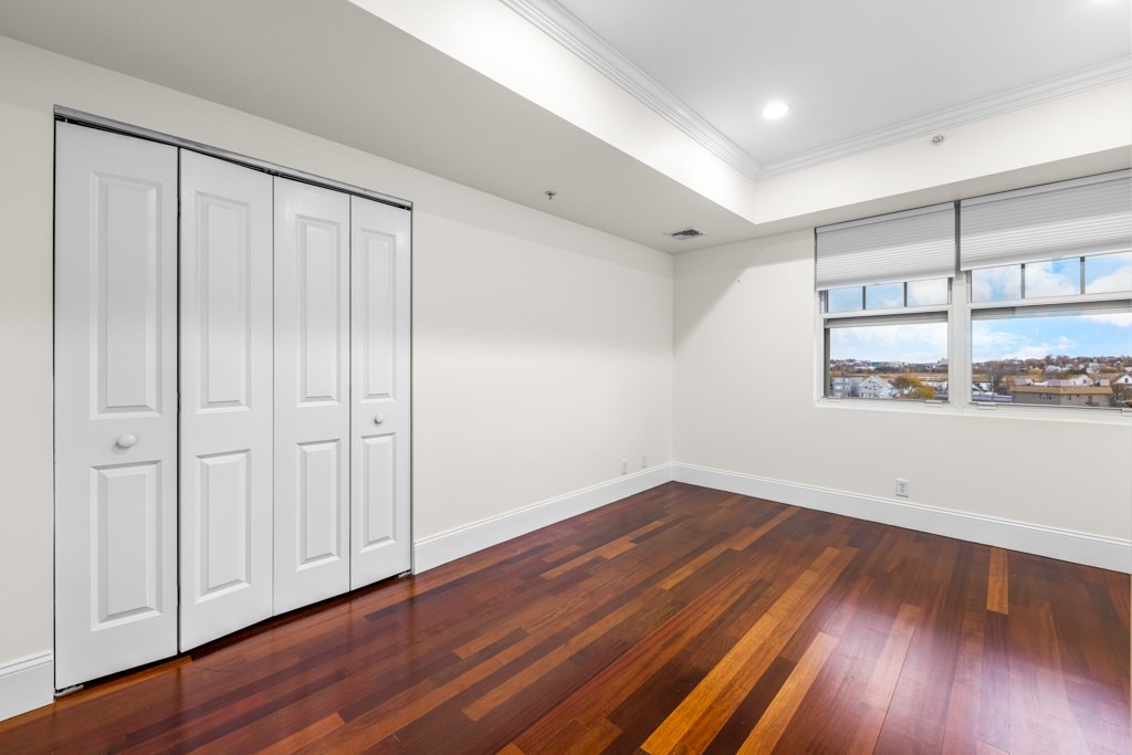 550 Pleasant Street, Unit 506 Winthrop, MA 02152 - Photo 13 of 21 a view of an empty room with wooden floor and a window