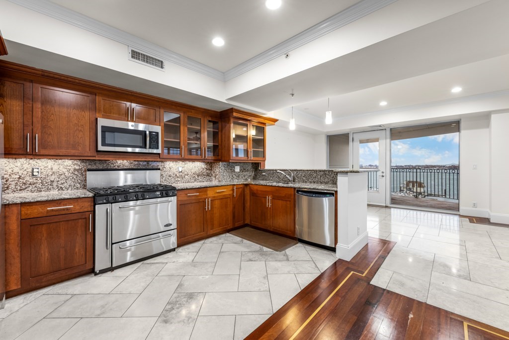 550 Pleasant Street, Unit 506 Winthrop, MA 02152 - Photo 9 of 21 a kitchen with stainless steel appliances granite countertop a stove granite counter tops and white cabinets