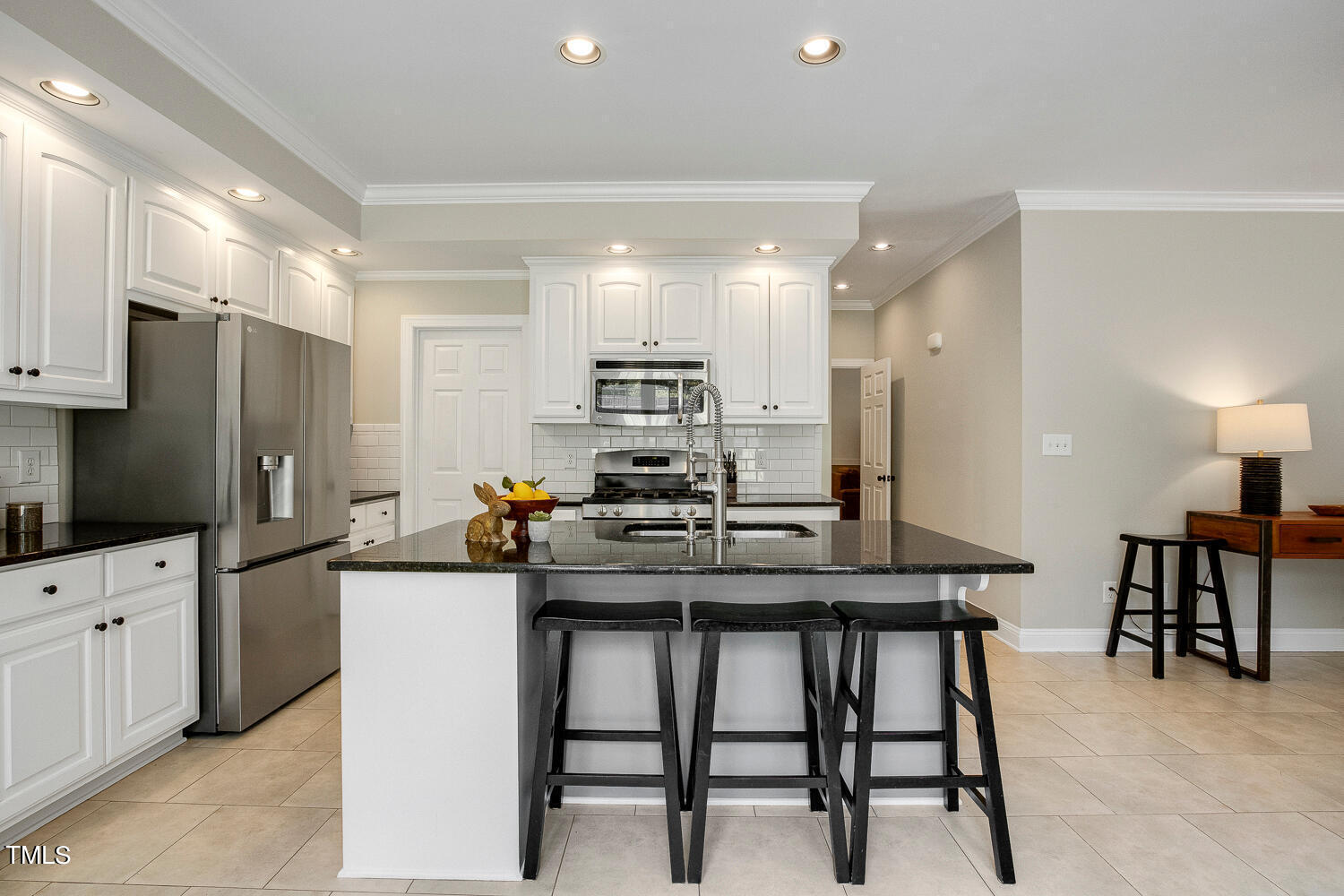 5809 Garrett Road Durham, NC 27707 - Photo 15 of 66 a kitchen with stainless steel appliances kitchen island granite countertop a table chairs microwave and sink