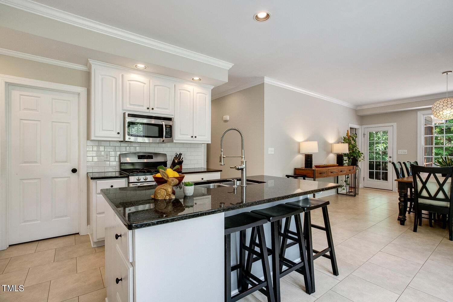 5809 Garrett Road Durham, NC 27707 - Photo 16 of 66 a kitchen with sink a stove and chairs
