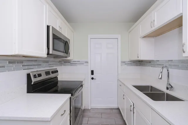 a kitchen with stainless steel appliances granite countertop a sink and a stove