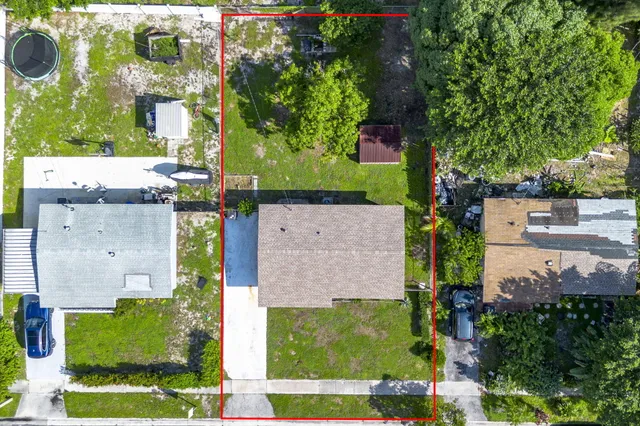 an aerial view of a house with a yard and large tree