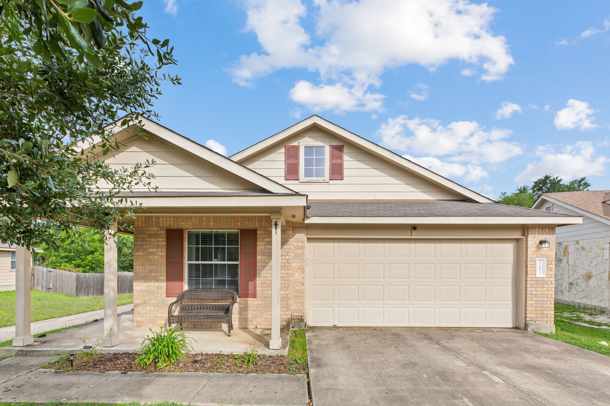 A charming single-story home with a classic brick facade and inviting covered front porch.