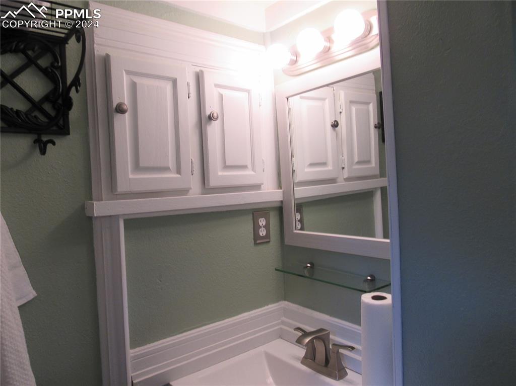 211 5th Street Victor, CO 80860 - Photo 12 of 22 a bathroom with a sink and a mirror