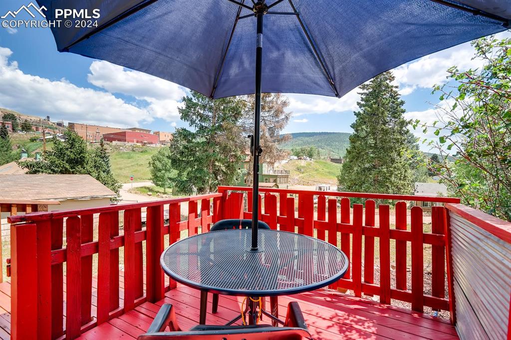 211 5th Street Victor, CO 80860 - Photo 18 of 22 a balcony with wooden floor and outdoor seating