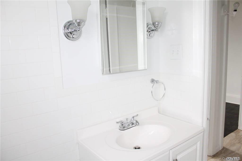 59-12 71st Street Queens, NY 11378 - Photo 12 of 26 a bathroom with a sink and mirror