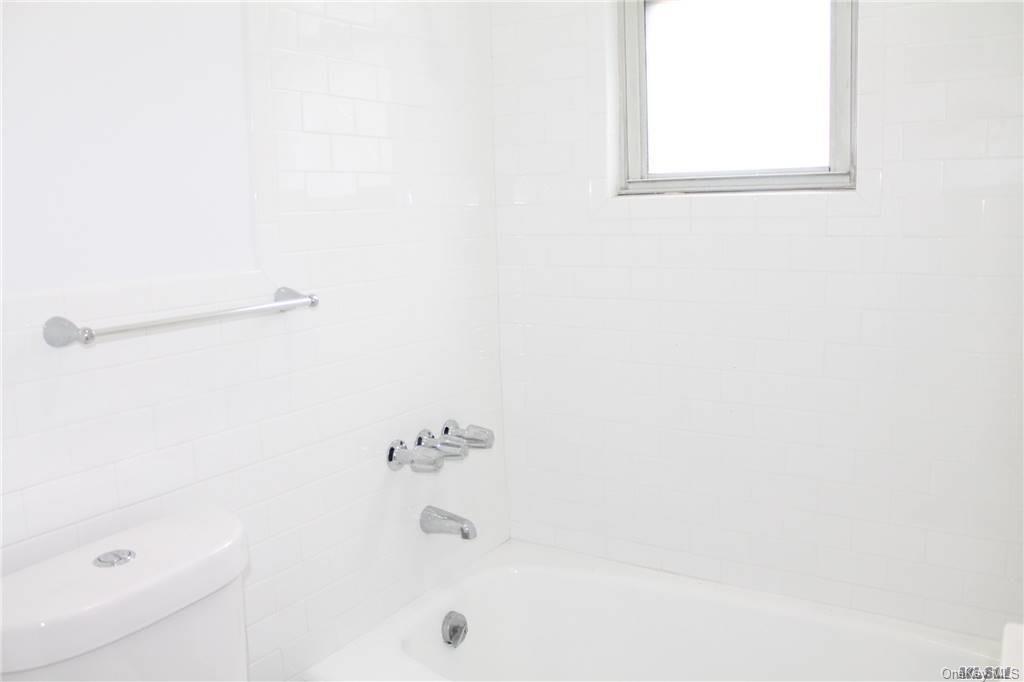 59-12 71st Street Queens, NY 11378 - Photo 13 of 26 a bathroom with a bathtub