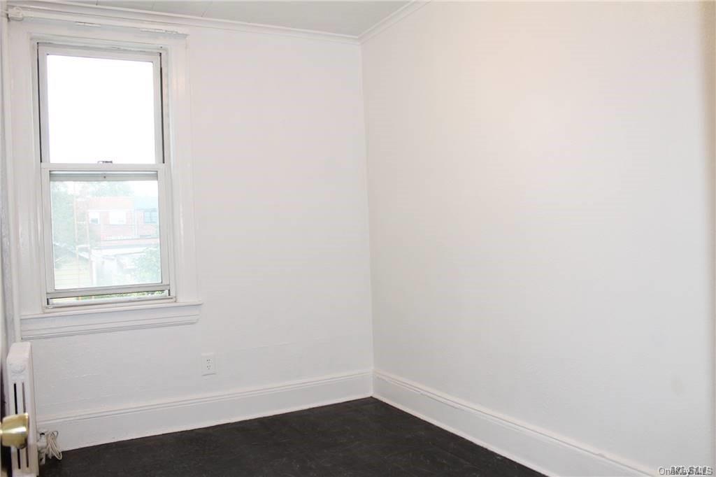 59-12 71st Street Queens, NY 11378 - Photo 15 of 26 an empty room with a window