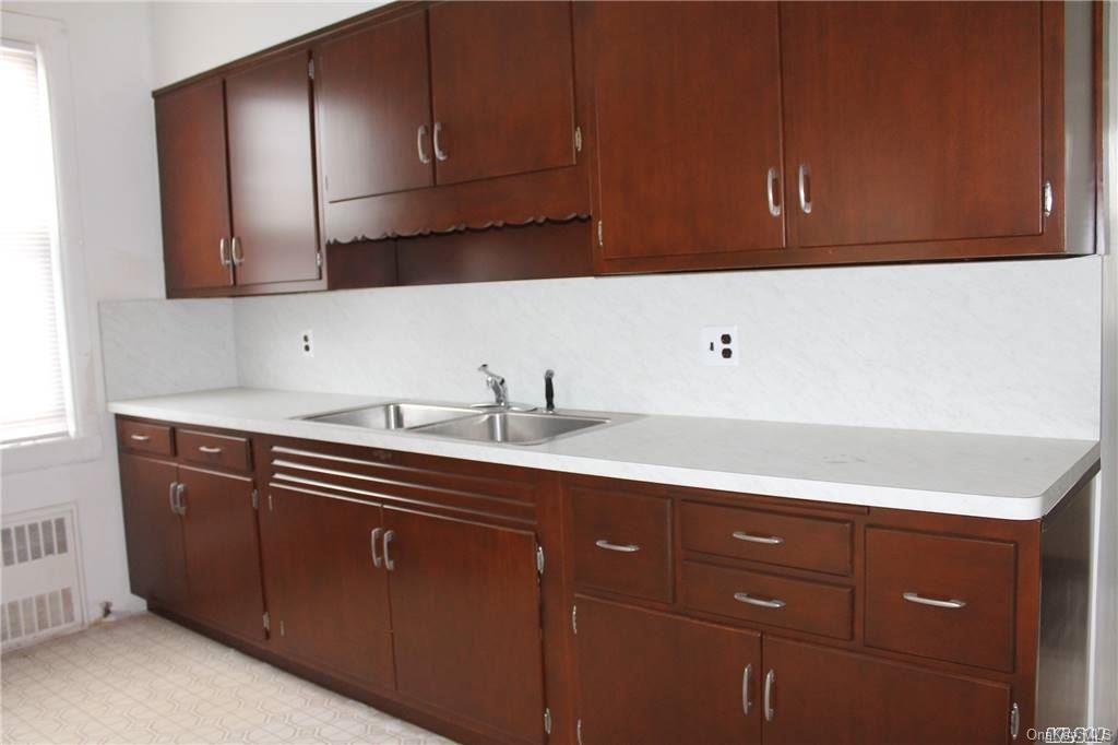 59-12 71st Street Queens, NY 11378 - Photo 19 of 26 a kitchen with a sink and cabinets