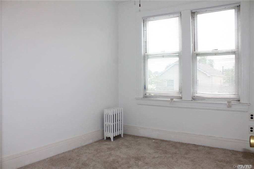 59-12 71st Street Queens, NY 11378 - Photo 22 of 26 an empty room with a window