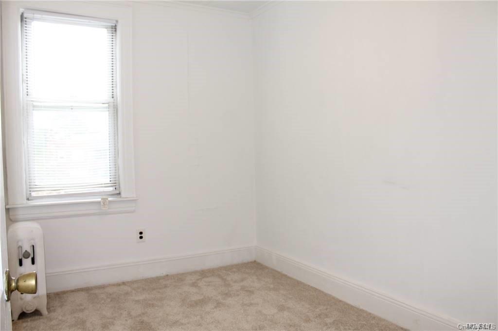 59-12 71st Street Queens, NY 11378 - Photo 23 of 26 an empty room with a window