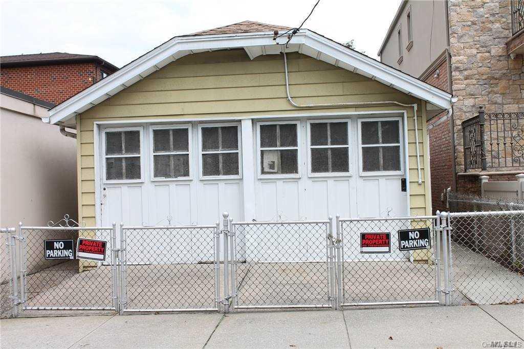 59-12 71st Street Queens, NY 11378 - Photo 6 of 26 a front view of a house with a garage